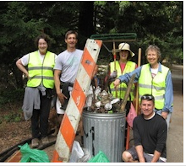 volunteers in front of large pile of collected trash