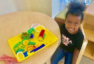 Photo of a Head Start student with toys